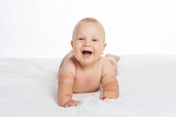 Aranyos mosolygós baba fekvő elszigetelt fehér törülközőt — Stock Fotó