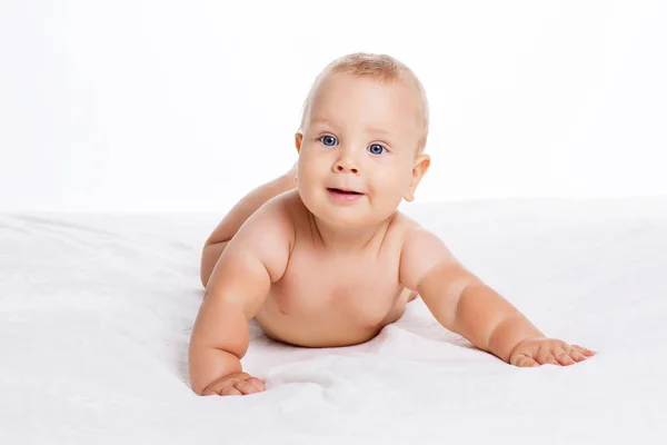 Leuke glimlachende baby liggend op een handdoek geïsoleerd op wit — Stockfoto