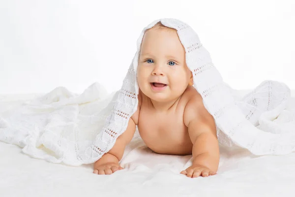 Милый улыбающийся ребенок под полотенцем после ванны — стоковое фото
