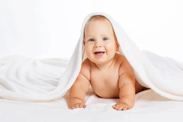 Bonito bebê sorridente sob toalha após o banho — Fotografia de Stock