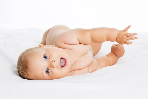 Leuke glimlachende baby liggend op een handdoek geïsoleerd op wit — Stockfoto