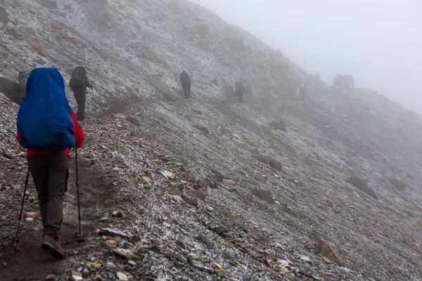 Trekker caminhando lentamente para Thorung La pass - o ponto mais alto em — Fotografia de Stock