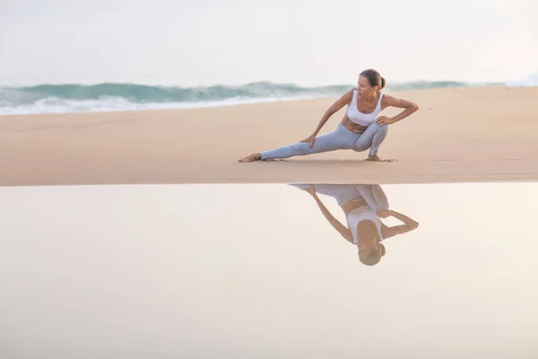Mujer caucásica practicando yoga en la orilla del mar del océano tropical — Foto de Stock