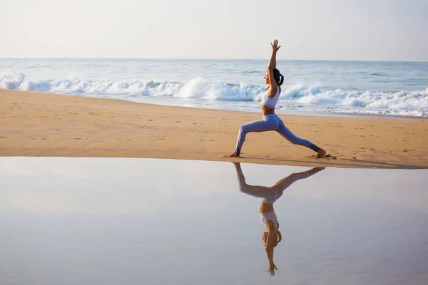 Wanita kaukasia berlatih yoga di pantai samudera tropis — Stok Foto