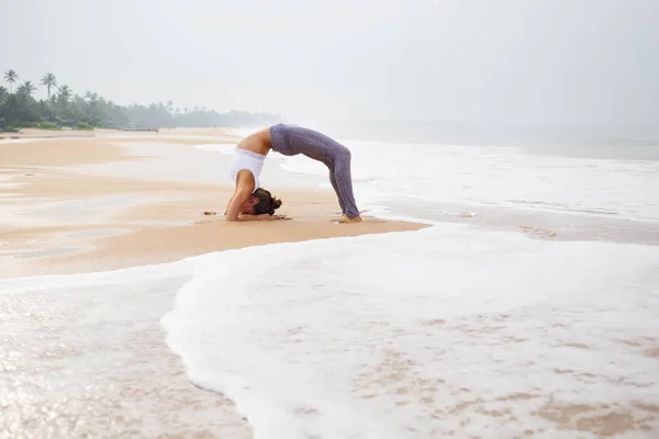 Mujer caucásica practicando yoga en la orilla del mar del océano tropical — Foto de Stock