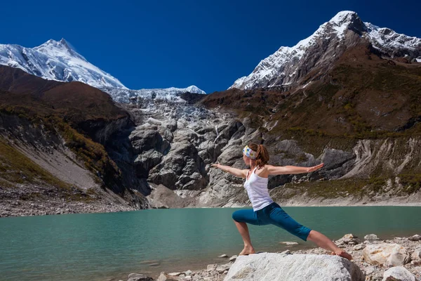 Frau macht Yoga-Übungen in der Nähe eines großen Sees im Manaslu Circ — Stockfoto