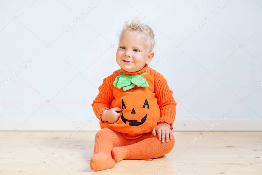 Small boy in pumpkin costume posing at studio
