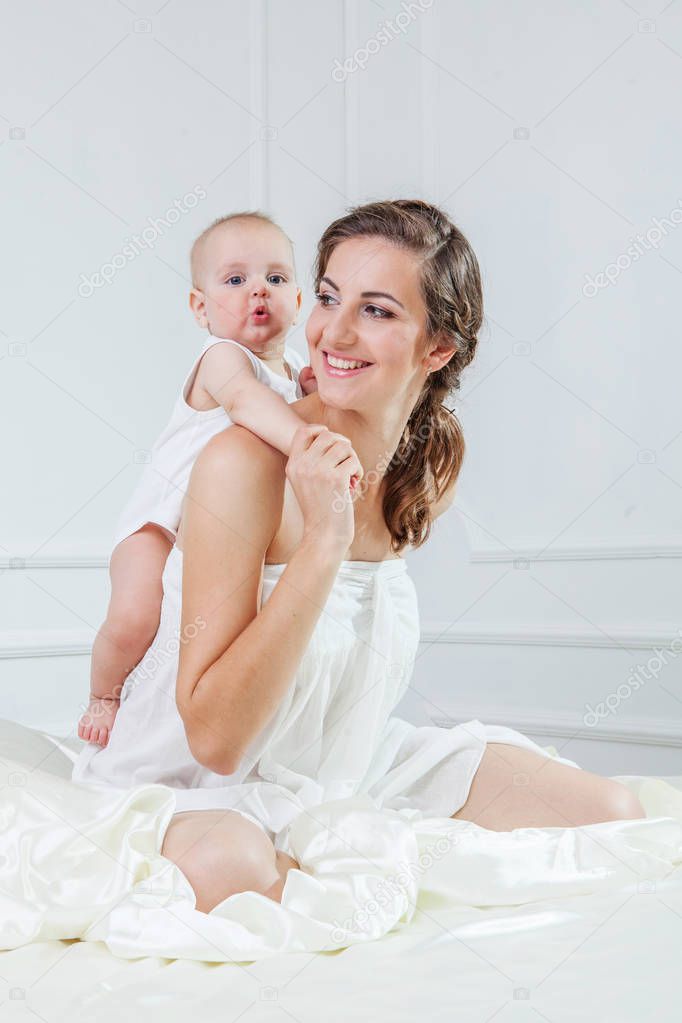 Happy family. Mother and her baby son playing and smilling on ba