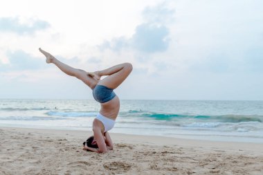 Doğal görünümlü hamile kadın seashore Yoga pratik bir