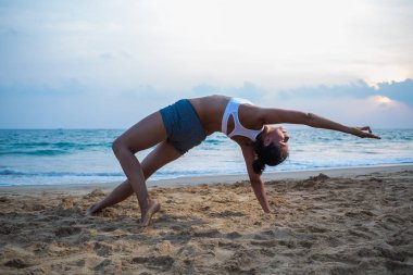 Doğal görünümlü hamile kadın seashore Yoga pratik bir