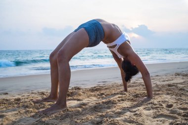 Doğal görünümlü hamile kadın seashore Yoga pratik bir