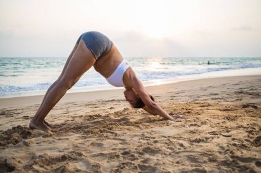 Doğal görünümlü hamile kadın seashore Yoga pratik bir