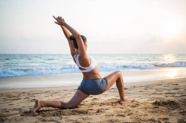 Doğal görünümlü hamile kadın seashore Yoga pratik bir
