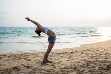 Doğal görünümlü hamile kadın seashore Yoga pratik bir
