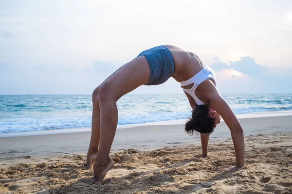 Doğal görünümlü hamile kadın seashore Yoga pratik bir