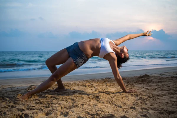 Mulher grávida de aparência natural praticando ioga na praia a — Fotografia de Stock