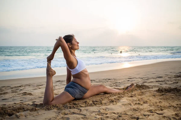 Doğal görünümlü hamile kadın seashore Yoga pratik bir