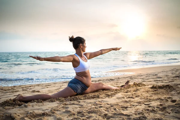 Doğal görünümlü hamile kadın seashore Yoga pratik bir