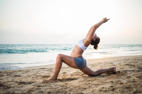 Naturliga gravid kvinna utövar yoga på stranden en — Stockfoto