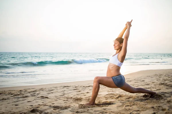 Naturliga gravid kvinna utövar yoga på stranden en — Stockfoto