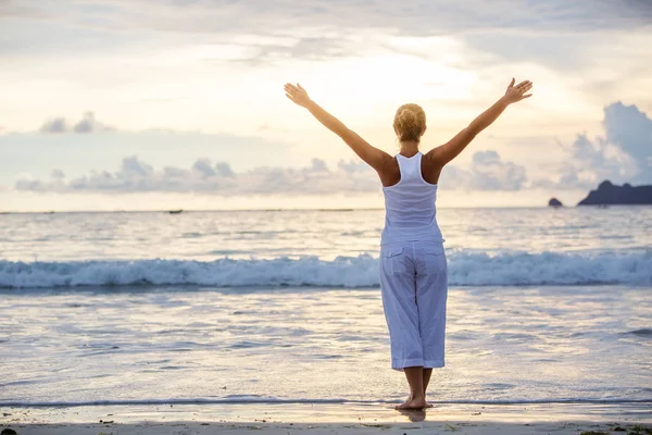 Kaukasiska kvinna utövar yoga på seashore av tropic ocean — Stockfoto