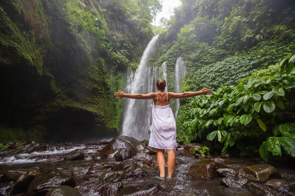 Kvinna som mediterar gör yoga mellan vattenfall — Stockfoto