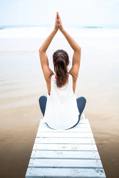 Frau praktiziert an bewölkten Tagen Yoga am Strand — Stockfoto