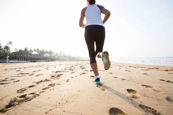 Kaukasisk kvinna jogging på havsstranden — Stockfoto