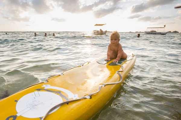 Kid se bavit na surfovací prkno v oceánu — Stock fotografie