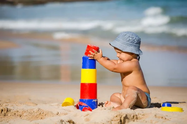 Dziecko bawi zabawki nad brzegiem morza w okresie letnim — Zdjęcie stockowe