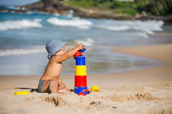 Dziecko bawi zabawki nad brzegiem morza w okresie letnim — Zdjęcie stockowe