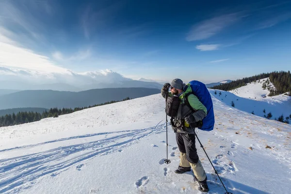 Uzun yürüyüşe çıkan kimse kış dağlarda kameraya poz — Stok fotoğraf
