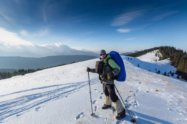 Caminante posando ante la cámara en las montañas de invierno — Foto de Stock