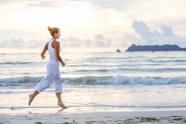 Kaukaski kobieta joggingu na seashore — Zdjęcie stockowe