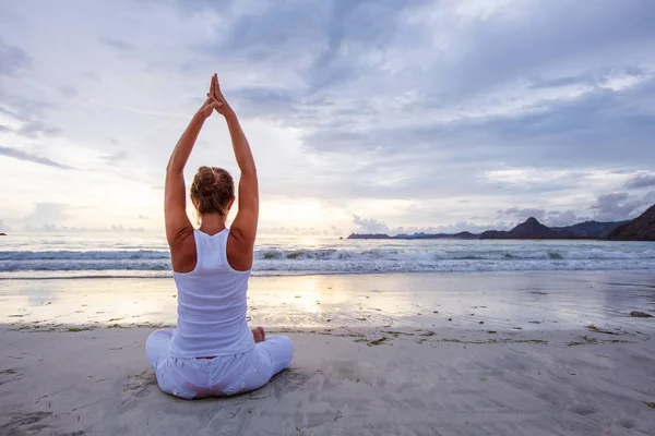 Mujer caucásica practicando yoga en la orilla del mar del océano tropical — Foto de Stock