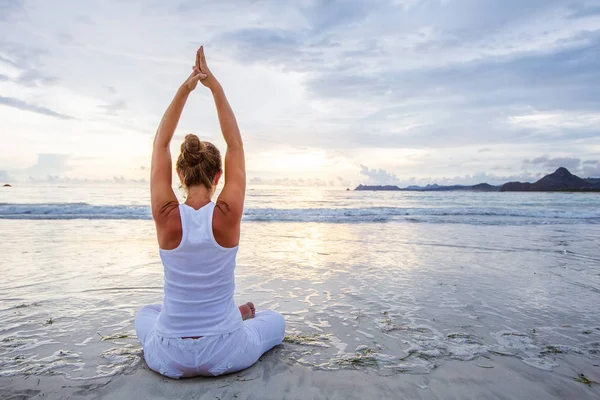 Mujer caucásica practicando yoga en la orilla del mar del océano tropical — Foto de Stock