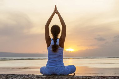 Kadın uygulamaları yoga gün batımında indone içinde seashore Bali