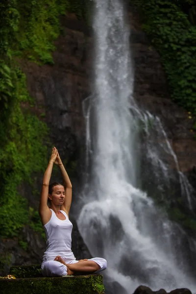 Woman practices yoga at Gitgit waterfall on Bali in indonesia — Stock Photo, Image