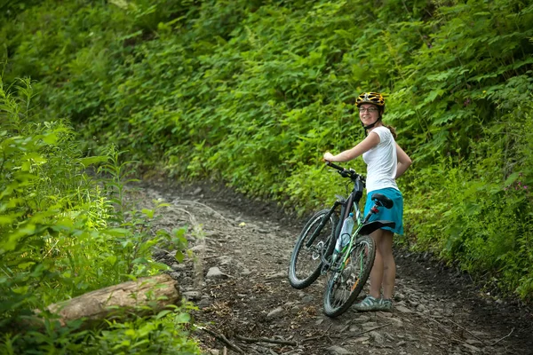 Biker popycha rower w zielonym lesie — Zdjęcie stockowe