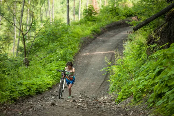 Motorcu yeşil ormanda Bisiklet iter