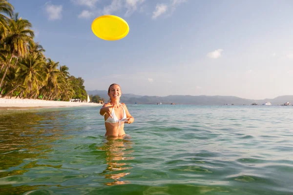Kvinna spelar frisbee i vackra havet vatten — Stockfoto
