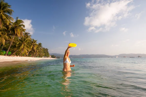 Wanita memainkan frisbee di air laut yang indah — Stok Foto