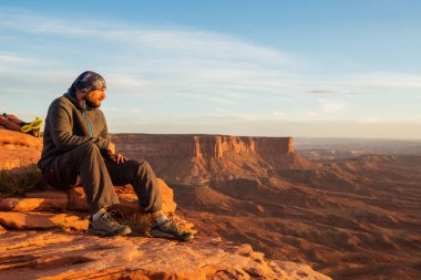 Uzun yürüyüşe çıkan kimse günbatımı Canyonlands Ulusal p Grand view noktasında karşılar