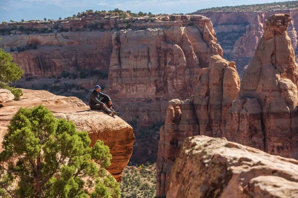 Caminhante está sentado no penhasco no monumento nacional do Colorado, EUA — Fotografia de Stock