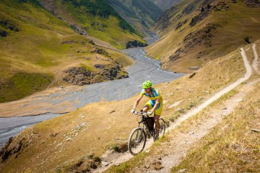 Dağ bisikletçinin Tusheti bölgesi dağlarında seyahat ediyor,