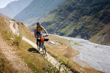Dağ bisikletçinin Tusheti bölgesi dağlarında seyahat ediyor,