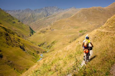 Dağ bisikletçinin Tusheti bölgesi dağlarında seyahat ediyor,