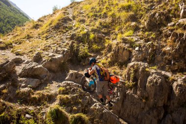 Motorcu Onun Bisiklet yüksek Kafkasya dağlarında iter