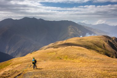 Dağ bisikletçinin Tusheti bölgesi dağlarında seyahat ediyor,