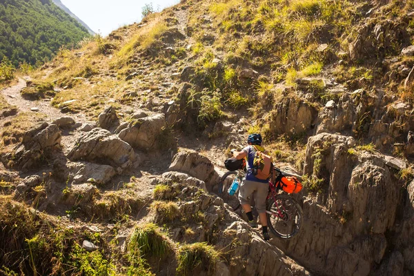 Motociclista empuja su bicicleta en las altas montañas del Cáucaso —  Fotos de Stock